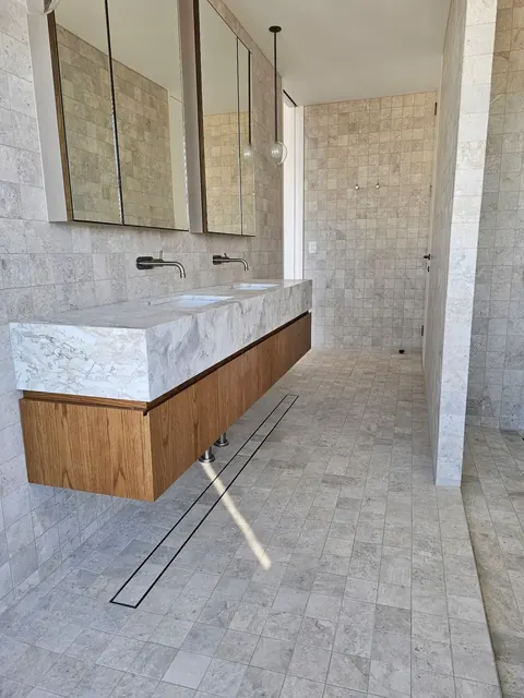 Stone-look tiled bathroom with a floating double vanity