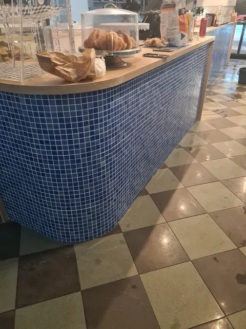 Blue mosaic curved café counter with a checkerboard floor