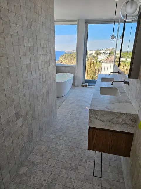 Tiled ensuite with a freestanding bath and coastal views