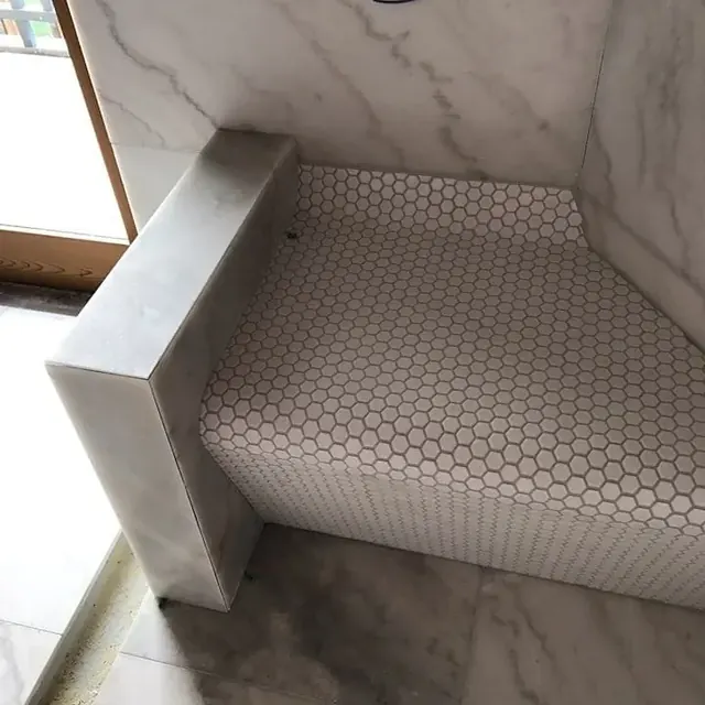 Marble shower bench with a hexagon mosaic floor