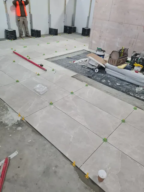 Large-format floor tiles being laid in a commercial fit-out