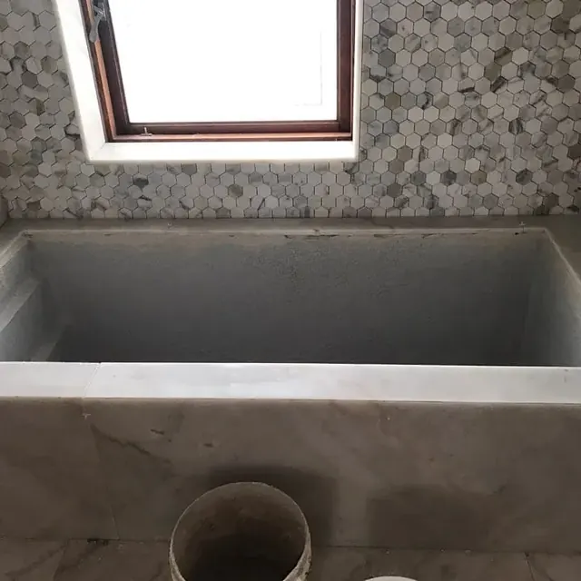 Marble bath surround with a hexagon mosaic feature wall