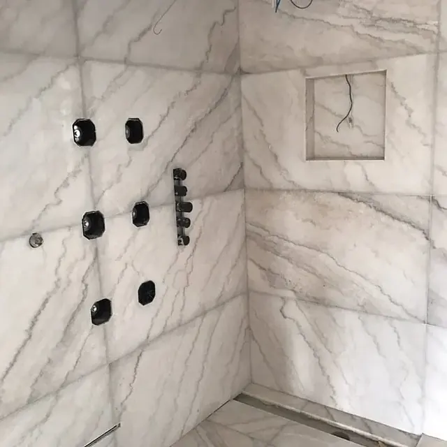 Marble shower wall with the fittings set out for plumbing
