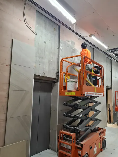 Tiling lift lobby walls from a scissor lift