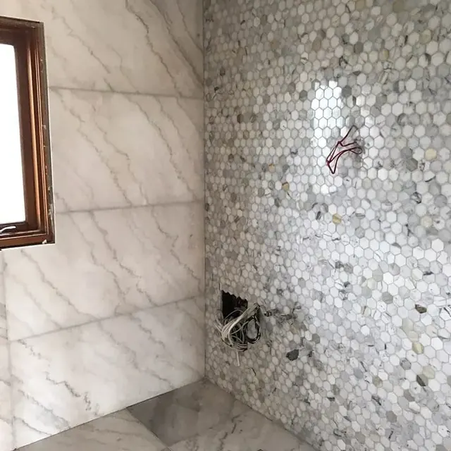 Marble walls with a hexagon mosaic feature in a bathroom