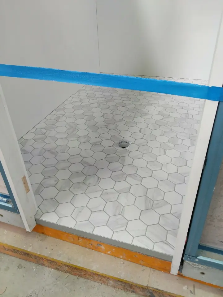 Hexagon mosaic shower floor graded to the waste