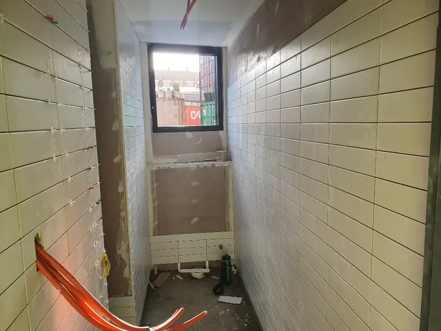 Large-format wall tiles in a room under renovation