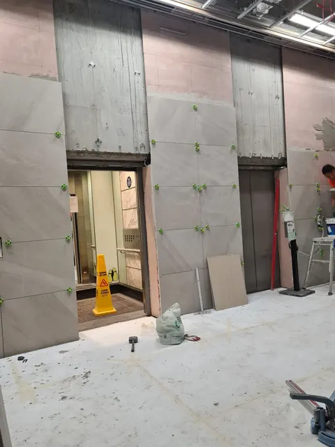 Large-format wall panels going up in a lift lobby
