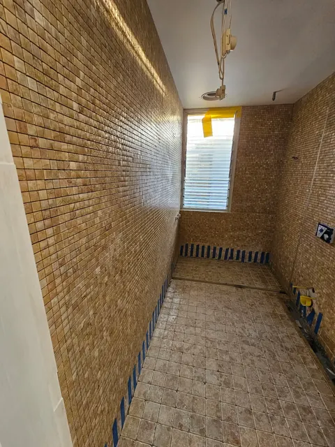 Amber glass mosaic bathroom walls during installation